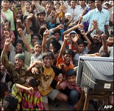 Watching the Oscars on tv in the Garibnagar slum where two child actors in the film live - pic from AFP 